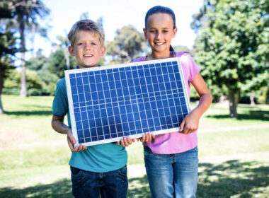Uczniowie trzymają panel słoneczny