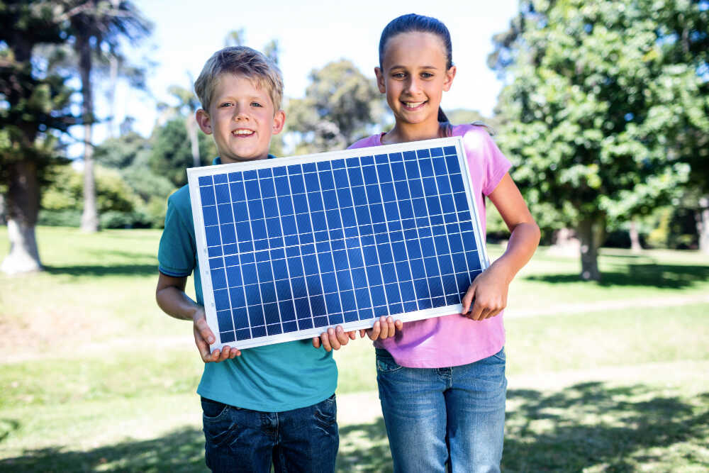 Uczniowie trzymają panel słoneczny